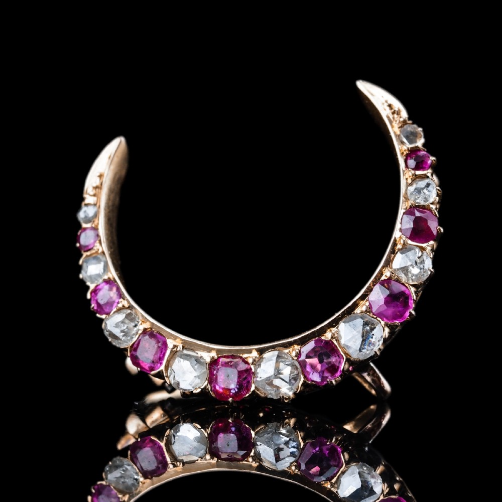 An 18K gold Victorian crescent moon brooch set with alternating cushion-cut rubies and old-cut diamonds. View V
