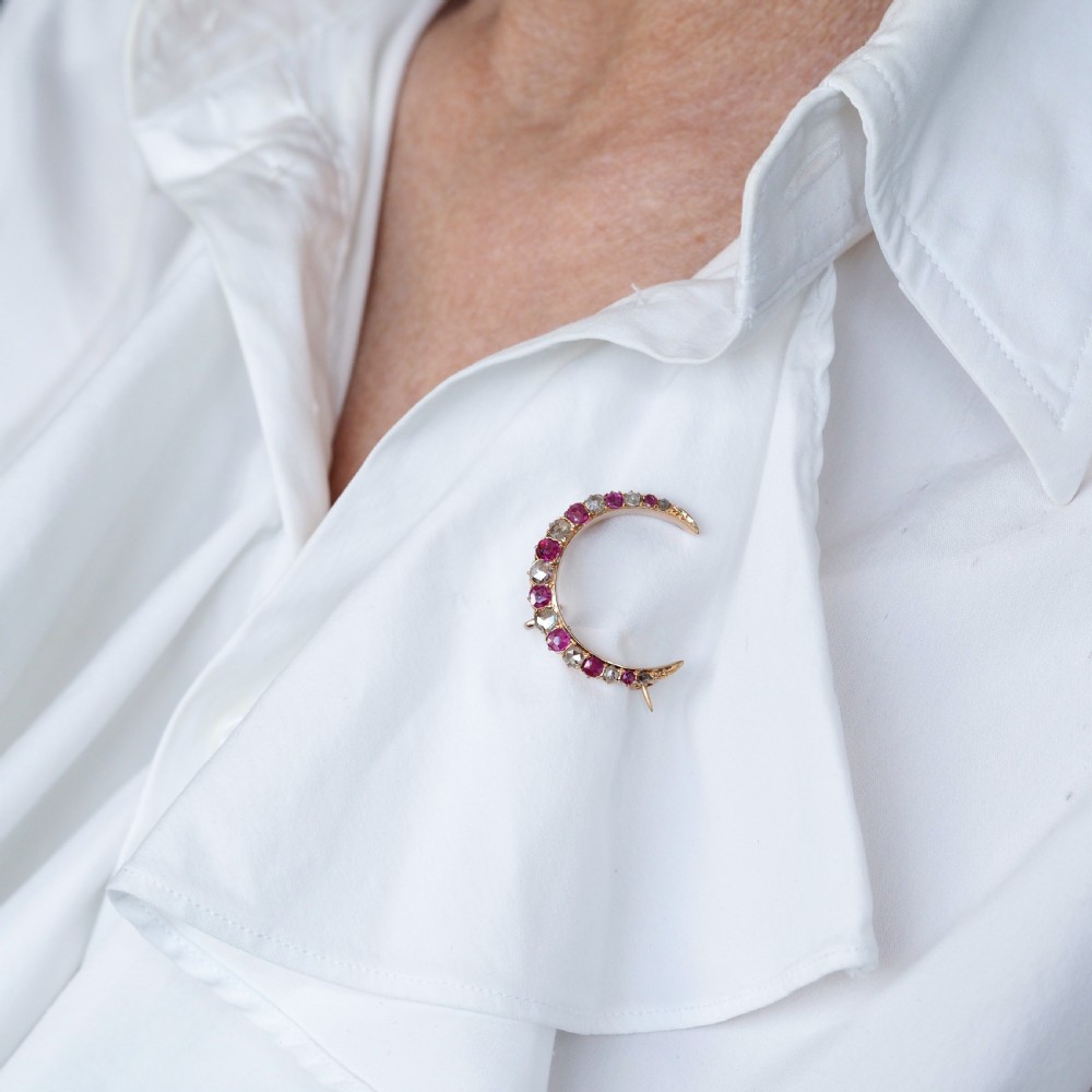 An 18K gold Victorian crescent moon brooch set with alternating cushion-cut rubies and old-cut diamonds. View IX