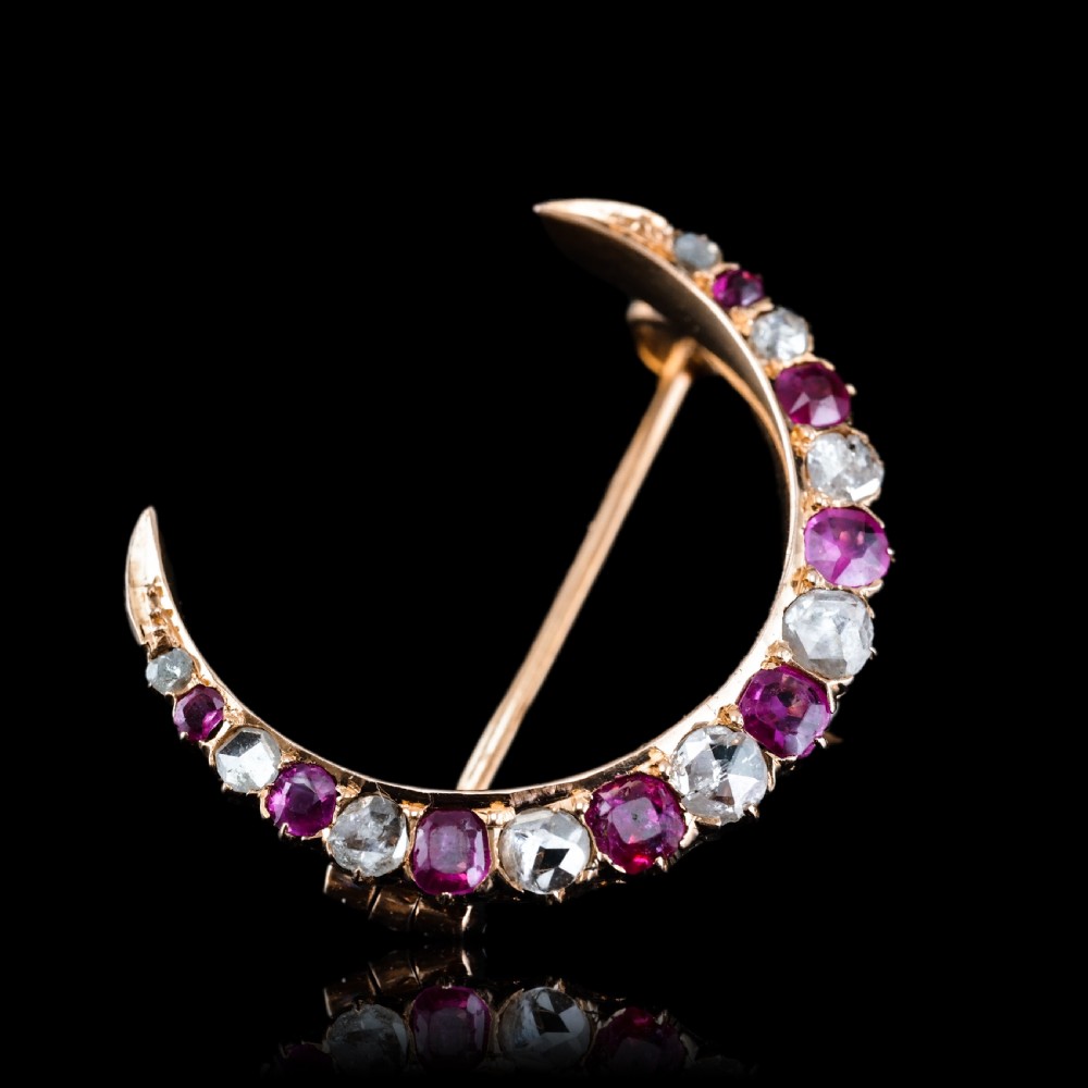An 18K gold Victorian crescent moon brooch set with alternating cushion-cut rubies and old-cut diamonds. View XVII