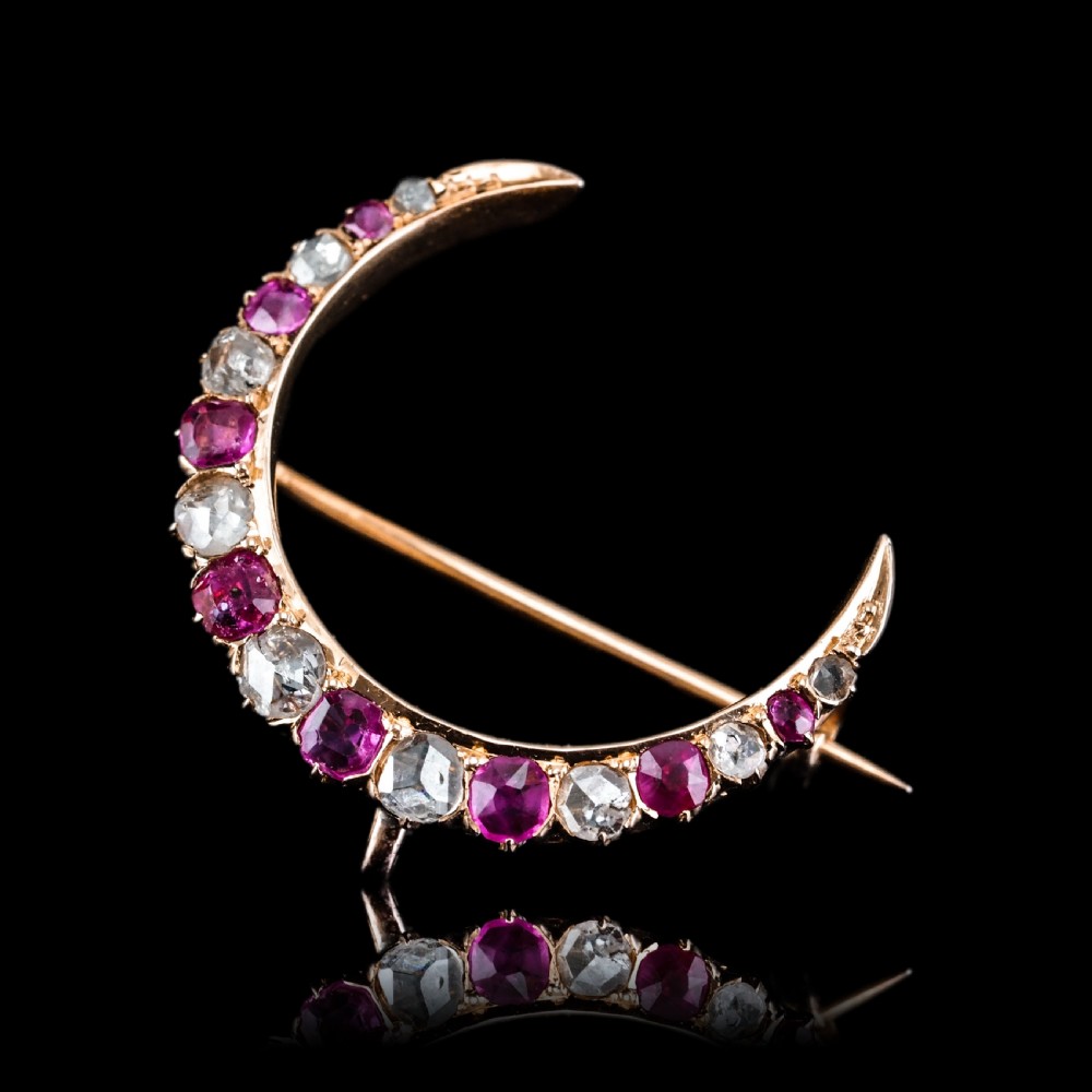 An 18K gold Victorian crescent moon brooch set with alternating cushion-cut rubies and old-cut diamonds. View XVIII