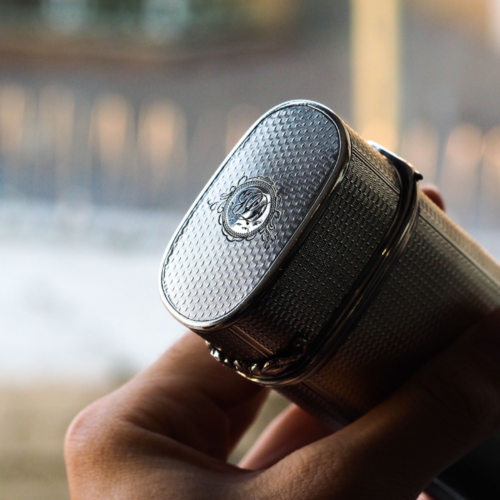 An antique engine-turned solid silver cigar case featuring floral relief thumbpiece detailing and an engraved cartouche on the end. View VIII