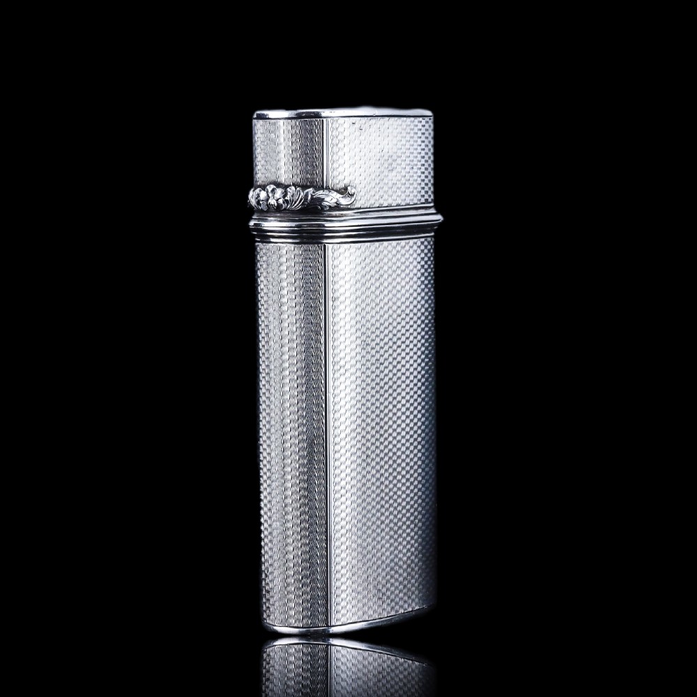 An antique engine-turned solid silver cigar case featuring floral relief thumbpiece detailing and an engraved cartouche on the end. View XI