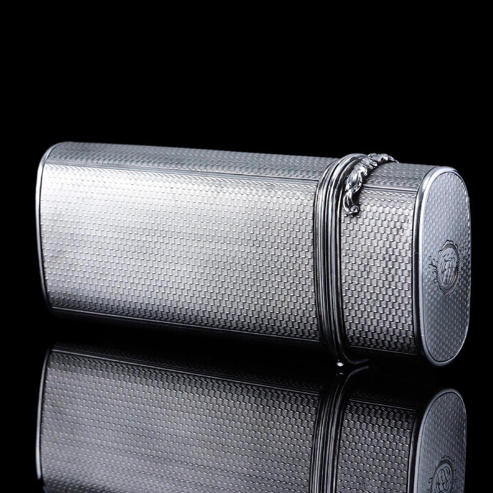 An antique engine-turned solid silver cigar case featuring floral relief thumbpiece detailing and an engraved cartouche on the end. View XV