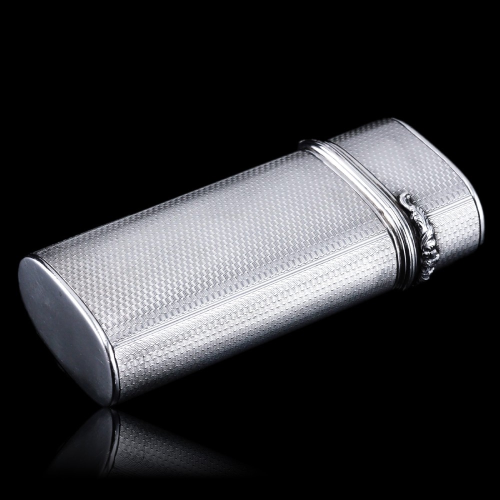 An antique engine-turned solid silver cigar case featuring floral relief thumbpiece detailing and an engraved cartouche on the end. View XXV