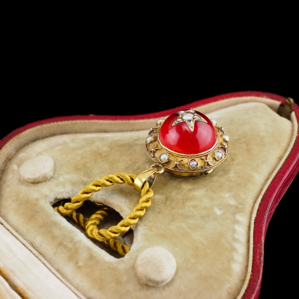 Victorian 15ct gold circular pendant featuring a red rock crystal cabochon accented with a diamond and pearl star motif and surrounded by a pearl border. View IX