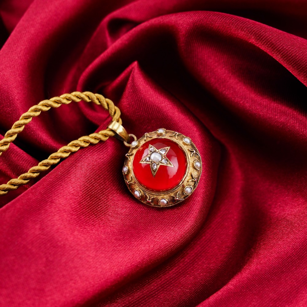 Victorian 15ct gold circular pendant featuring a red rock crystal cabochon accented with a diamond and pearl star motif and surrounded by a pearl border. View XIII