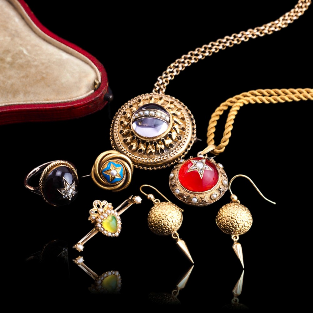 Victorian 15ct gold circular pendant featuring a red rock crystal cabochon accented with a diamond and pearl star motif and surrounded by a pearl border. View XIV