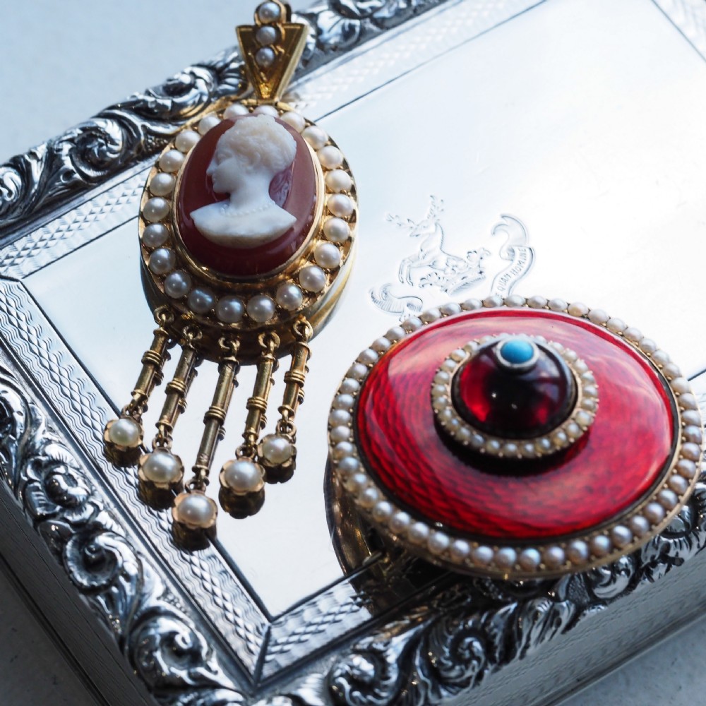 A Victorian 14K gold oval pendant featuring a carved white shell cameo profile against a brown background, framed by a border of seed pearls with articulated pearl drops. View IV
