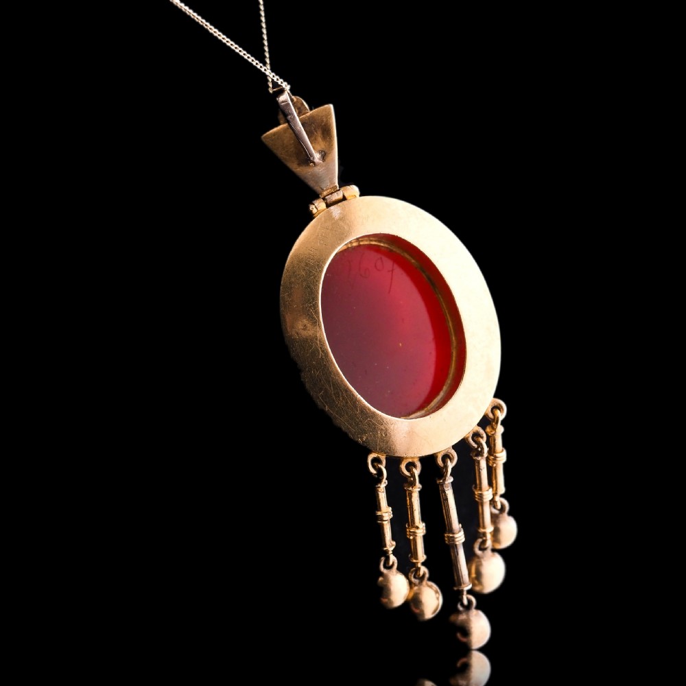 A Victorian 14K gold oval pendant featuring a carved white shell cameo profile against a brown background, framed by a border of seed pearls with articulated pearl drops. View XI