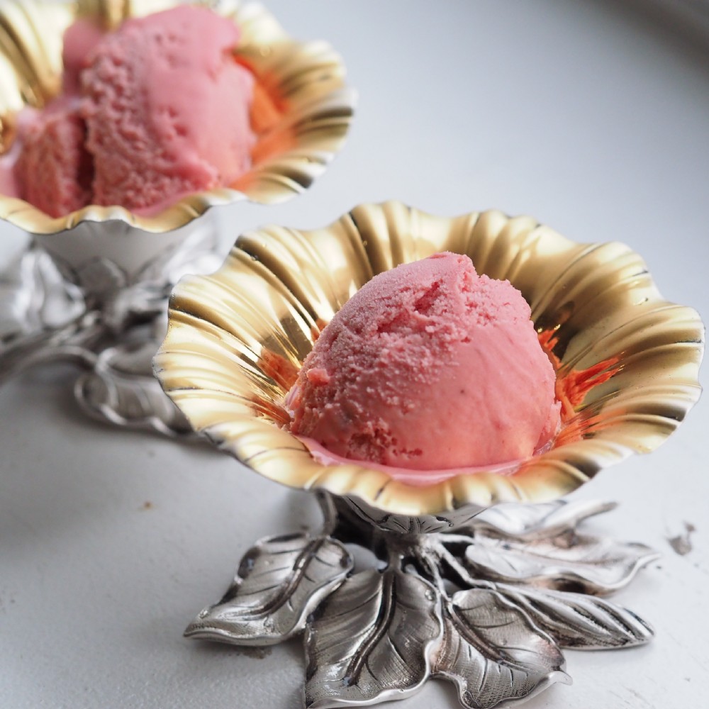 A pair of William IV sterling silver salt cellars designed as open flower heads with gilded interiors resting on naturalistic leaf bases. View II