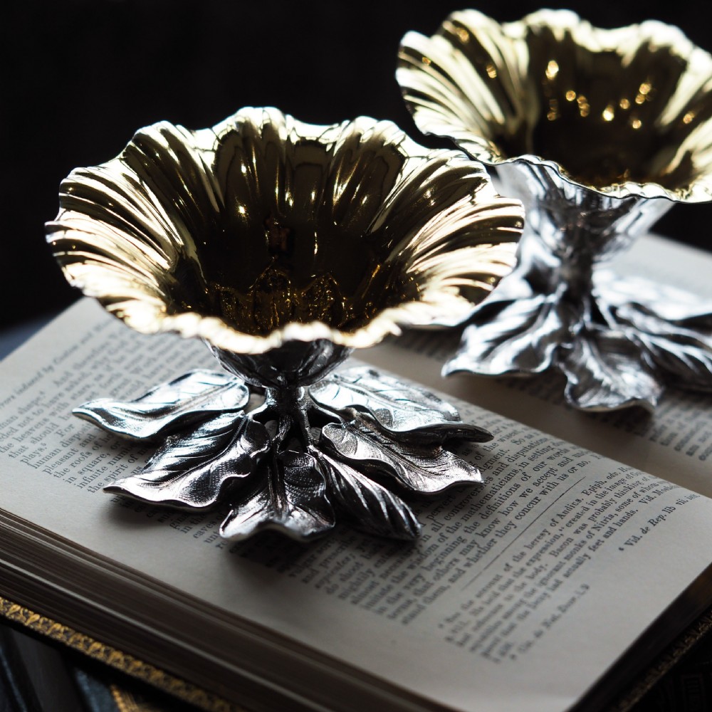 A pair of William IV sterling silver salt cellars designed as open flower heads with gilded interiors resting on naturalistic leaf bases. View VI