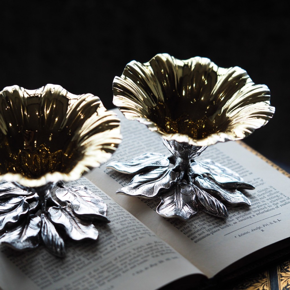 A pair of William IV sterling silver salt cellars designed as open flower heads with gilded interiors resting on naturalistic leaf bases. View VII