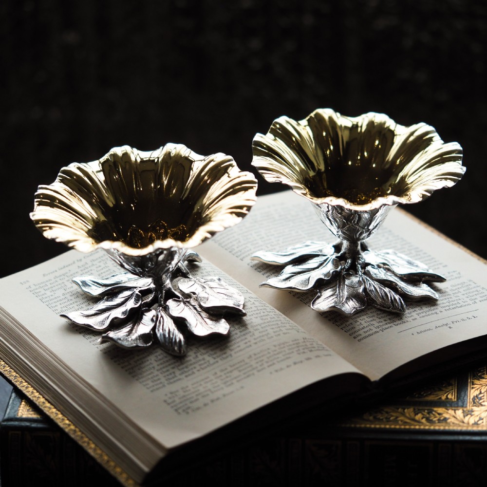 A pair of William IV sterling silver salt cellars designed as open flower heads with gilded interiors resting on naturalistic leaf bases. View VIII