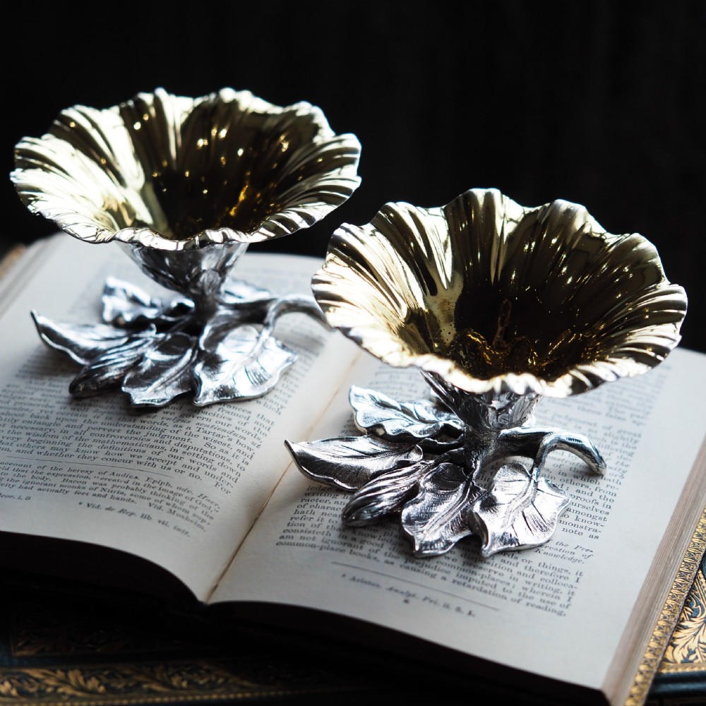 A pair of William IV sterling silver salt cellars designed as open flower heads with gilded interiors resting on naturalistic leaf bases. View IX