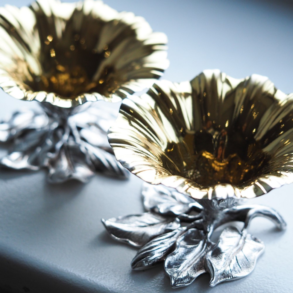 A pair of William IV sterling silver salt cellars designed as open flower heads with gilded interiors resting on naturalistic leaf bases. View X
