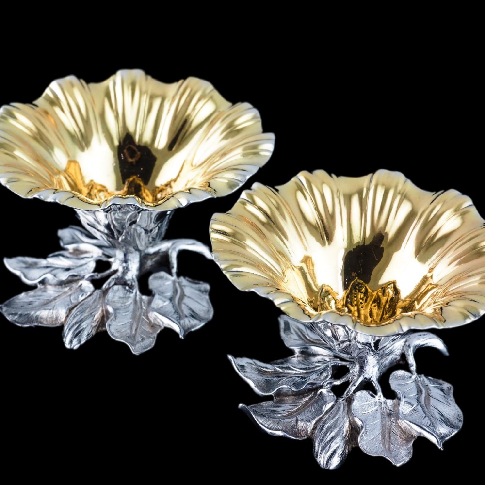 A pair of William IV sterling silver salt cellars designed as open flower heads with gilded interiors resting on naturalistic leaf bases. View XII