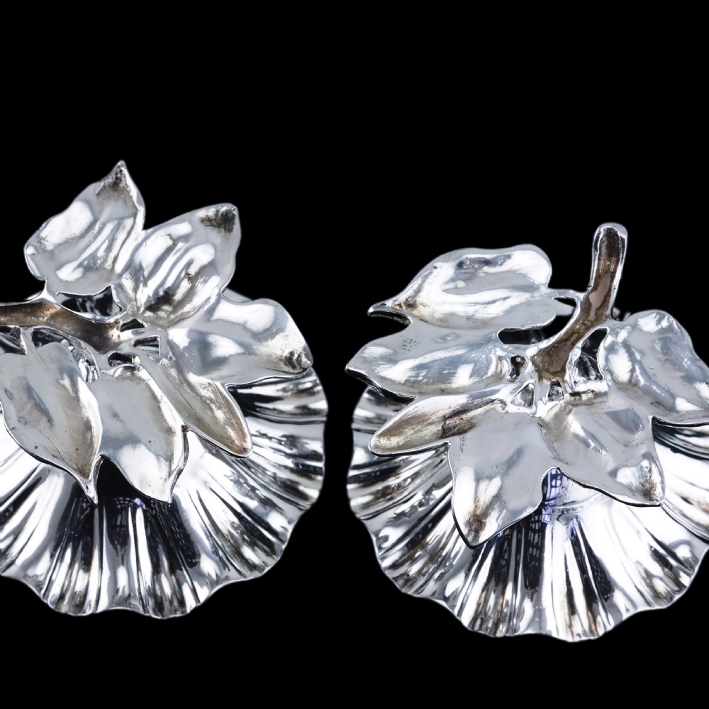 A pair of William IV sterling silver salt cellars designed as open flower heads with gilded interiors resting on naturalistic leaf bases. View XIV
