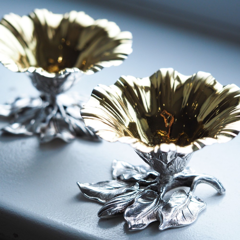 A pair of William IV sterling silver salt cellars designed as open flower heads with gilded interiors resting on naturalistic leaf bases. View XX