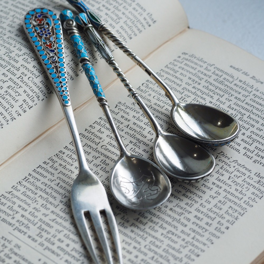 A four-piece set of late 19th-century Russian silver and cloisonne enamel cutlery featuring three spoons and a fork with turquoise blue, white, and red floral motifs. View VII