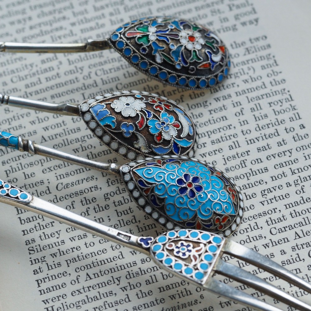 A four-piece set of late 19th-century Russian silver and cloisonne enamel cutlery featuring three spoons and a fork with turquoise blue, white, and red floral motifs. View IX