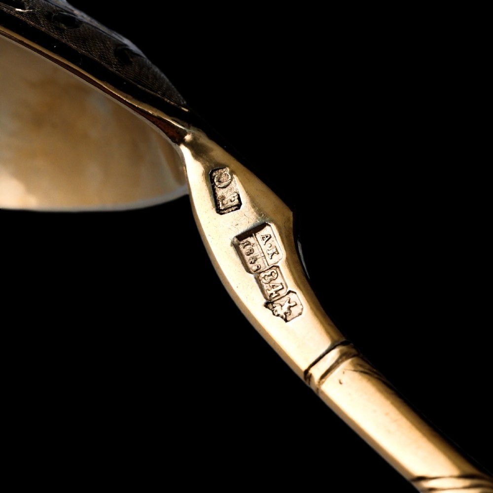 An antique Russian silver-gilt serving spoon featuring intricate black niello foliate engraving across the back of the oval bowl and a turned stem. View XIV