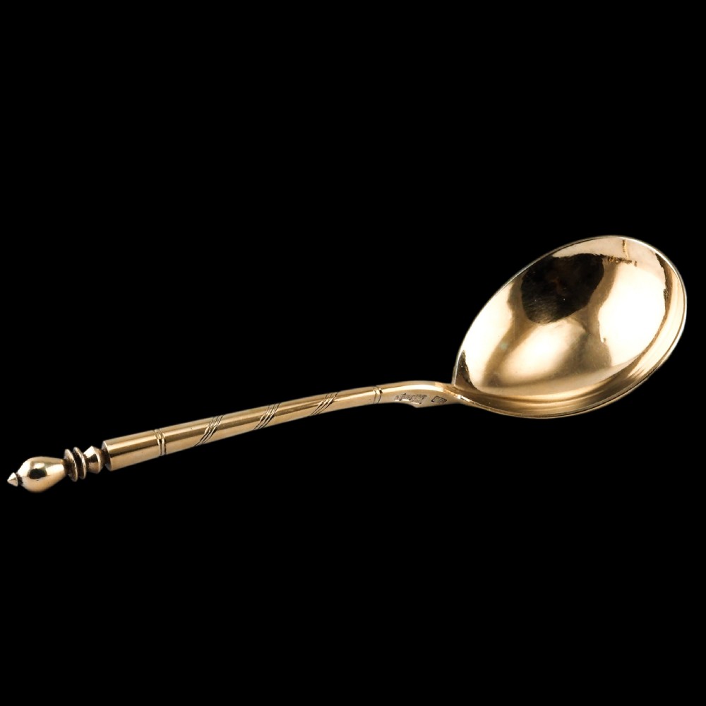 An antique Russian silver-gilt serving spoon featuring intricate black niello foliate engraving across the back of the oval bowl and a turned stem. View XXI