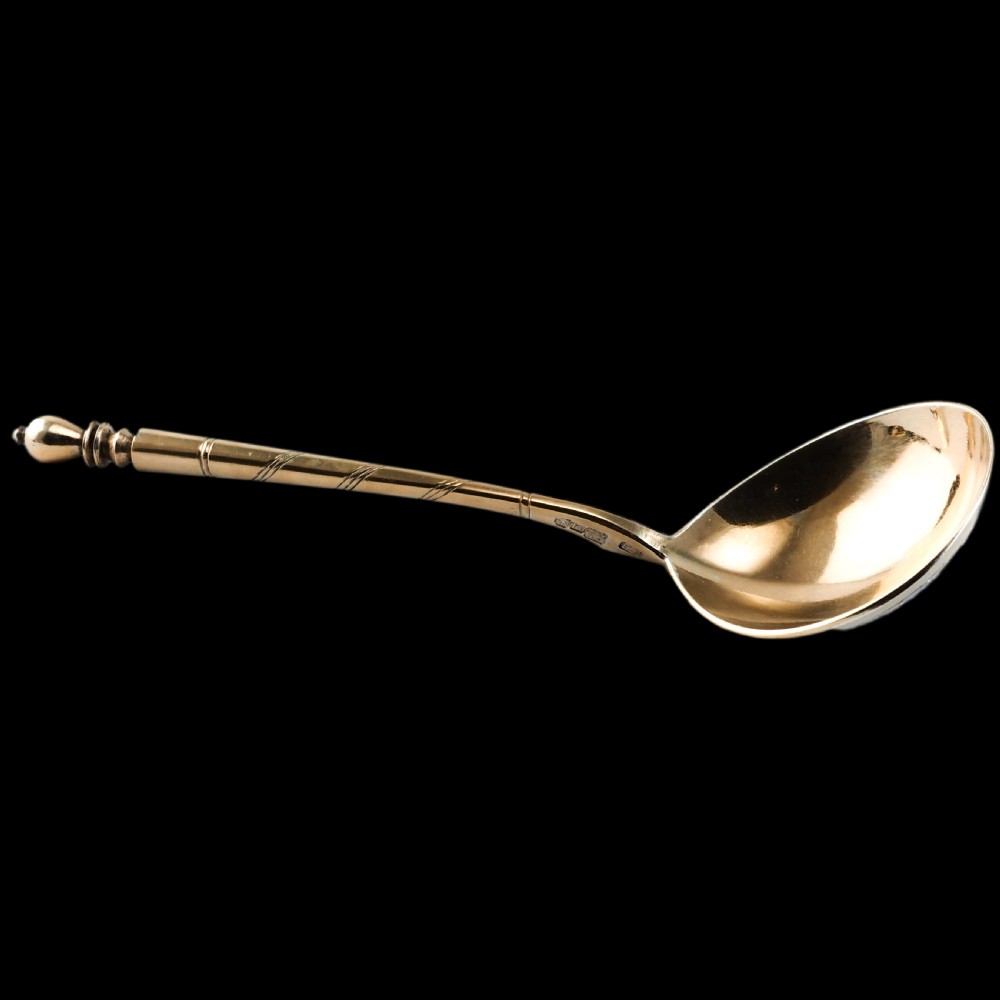 An antique Russian silver-gilt serving spoon featuring intricate black niello foliate engraving across the back of the oval bowl and a turned stem. View XXII
