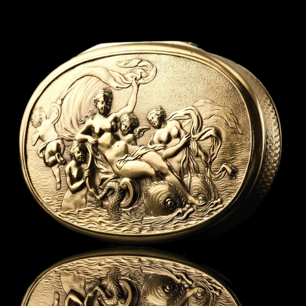 An oval Georgian silver-gilt snuff box featuring a relief scene of Venus surrounded by attendants and sea creatures on the lid.