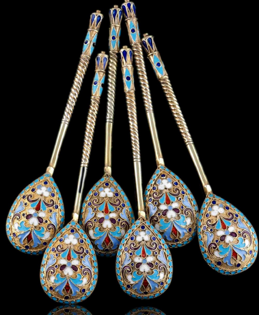 Set of six antique Russian silver gilt spoons featuring blue, red, and white cloisonne enamel scrollwork on the backs of the teardrop-shaped bowls.