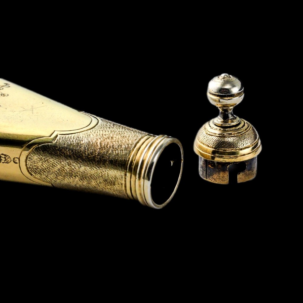 A seventeenth-century teardrop-shaped silver gilt scent flask engraved with a coronet and crest, positioned alongside its dark leather case. View XXI