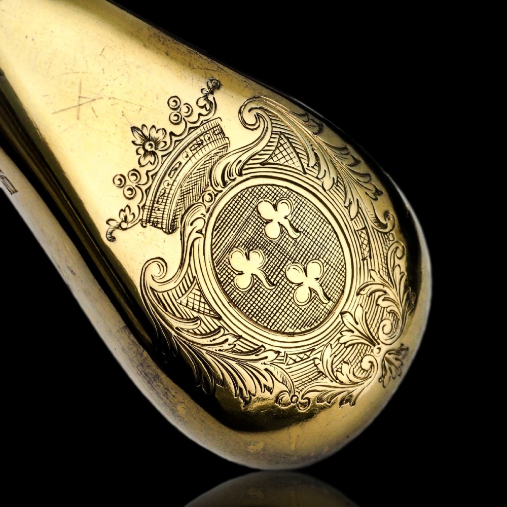 A seventeenth-century teardrop-shaped silver gilt scent flask engraved with a coronet and crest, positioned alongside its dark leather case. View XXV