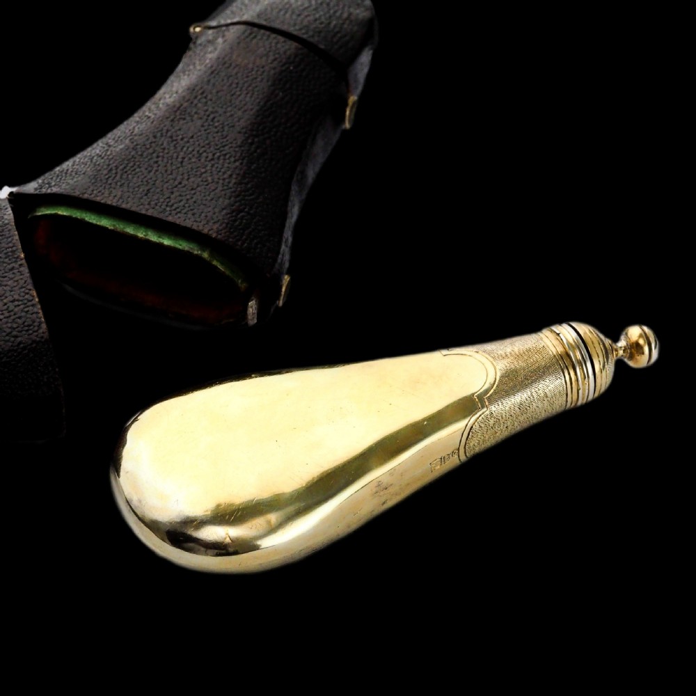 A seventeenth-century teardrop-shaped silver gilt scent flask engraved with a coronet and crest, positioned alongside its dark leather case. View XXVII