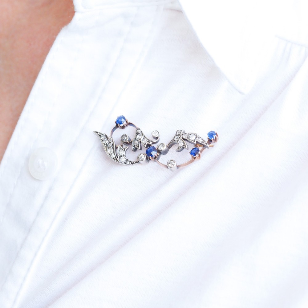 An antique Victorian foliate scroll brooch crafted in gold and silver, set with circular blue sapphires and accent diamonds. View VII
