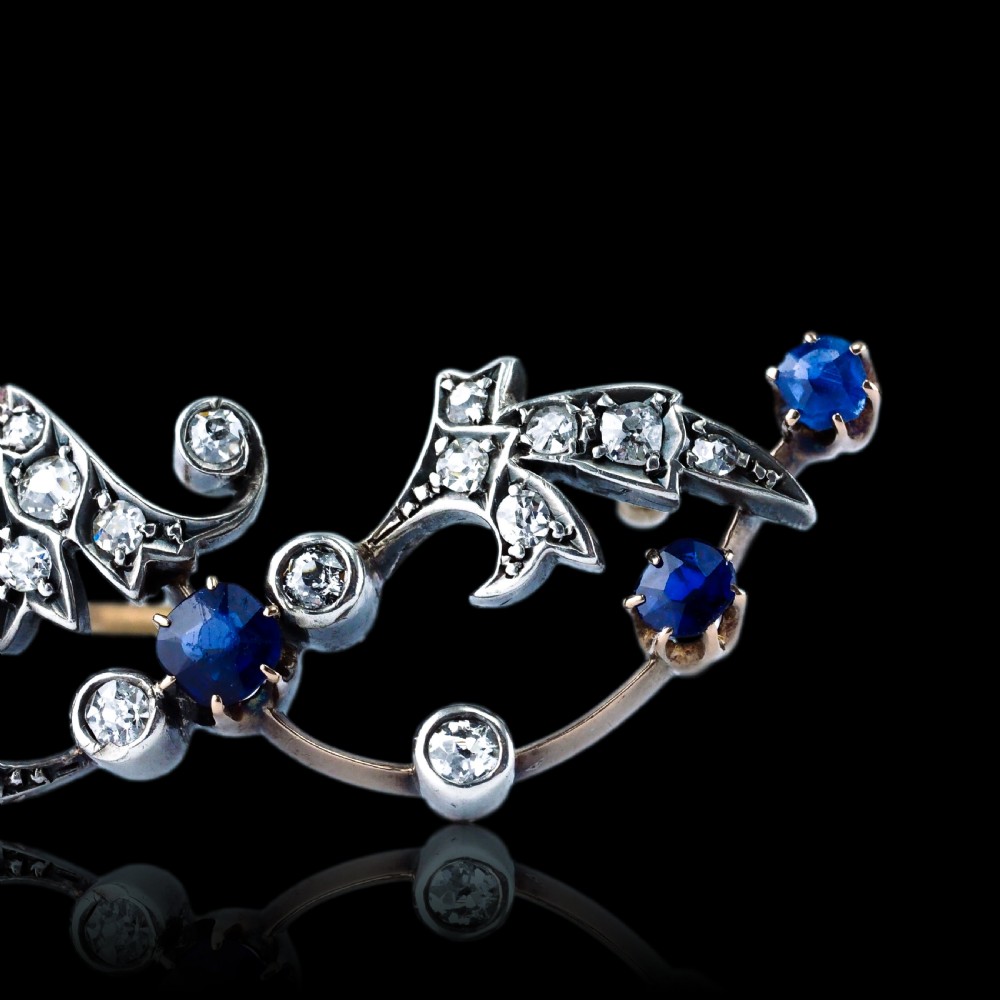 An antique Victorian foliate scroll brooch crafted in gold and silver, set with circular blue sapphires and accent diamonds. View XI
