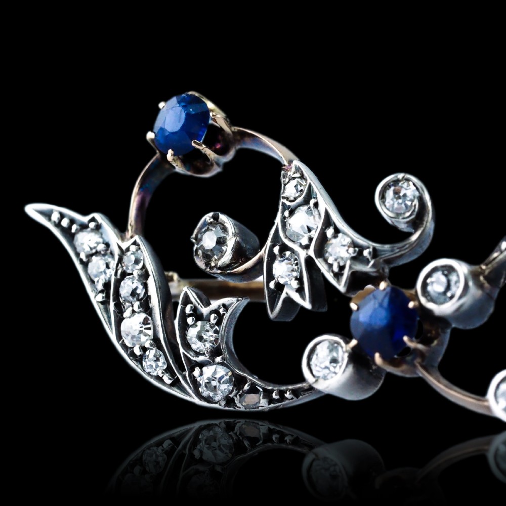 An antique Victorian foliate scroll brooch crafted in gold and silver, set with circular blue sapphires and accent diamonds. View XII