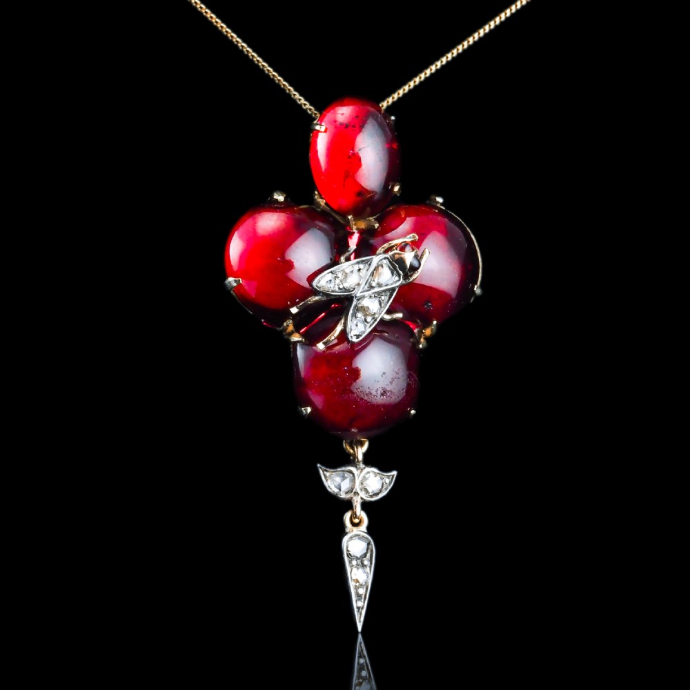 Victorian gold brooch pendant set with four deep red cabochon garnets, a diamond-encrusted insect motif at the centre, and an articulated diamond drop. View III