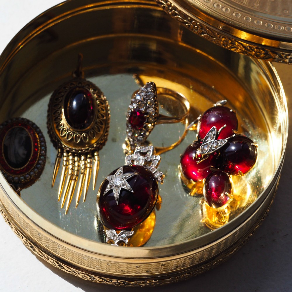 Victorian gold brooch pendant set with four deep red cabochon garnets, a diamond-encrusted insect motif at the centre, and an articulated diamond drop. View XXVIII
