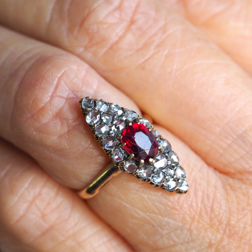 An antique late-nineteenth-century French 18k gold navette cluster ring featuring a central oval red ruby surrounded by multiple rose-cut diamonds. View XI