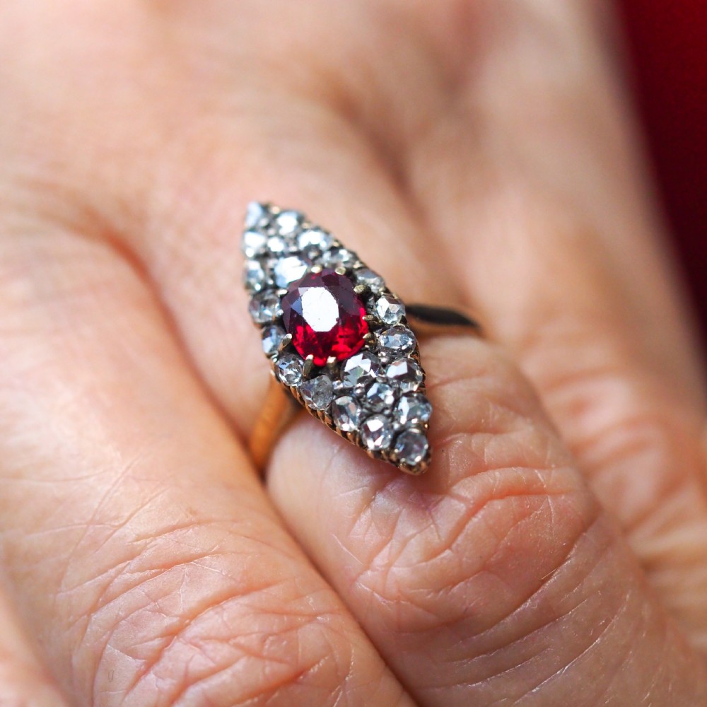 An antique late-nineteenth-century French 18k gold navette cluster ring featuring a central oval red ruby surrounded by multiple rose-cut diamonds. View XIII