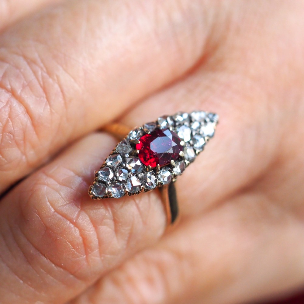 An antique late-nineteenth-century French 18k gold navette cluster ring featuring a central oval red ruby surrounded by multiple rose-cut diamonds. View XIV
