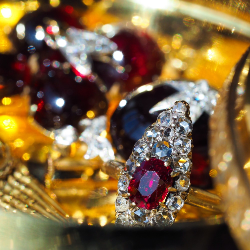 An antique late-nineteenth-century French 18k gold navette cluster ring featuring a central oval red ruby surrounded by multiple rose-cut diamonds. View XXIII