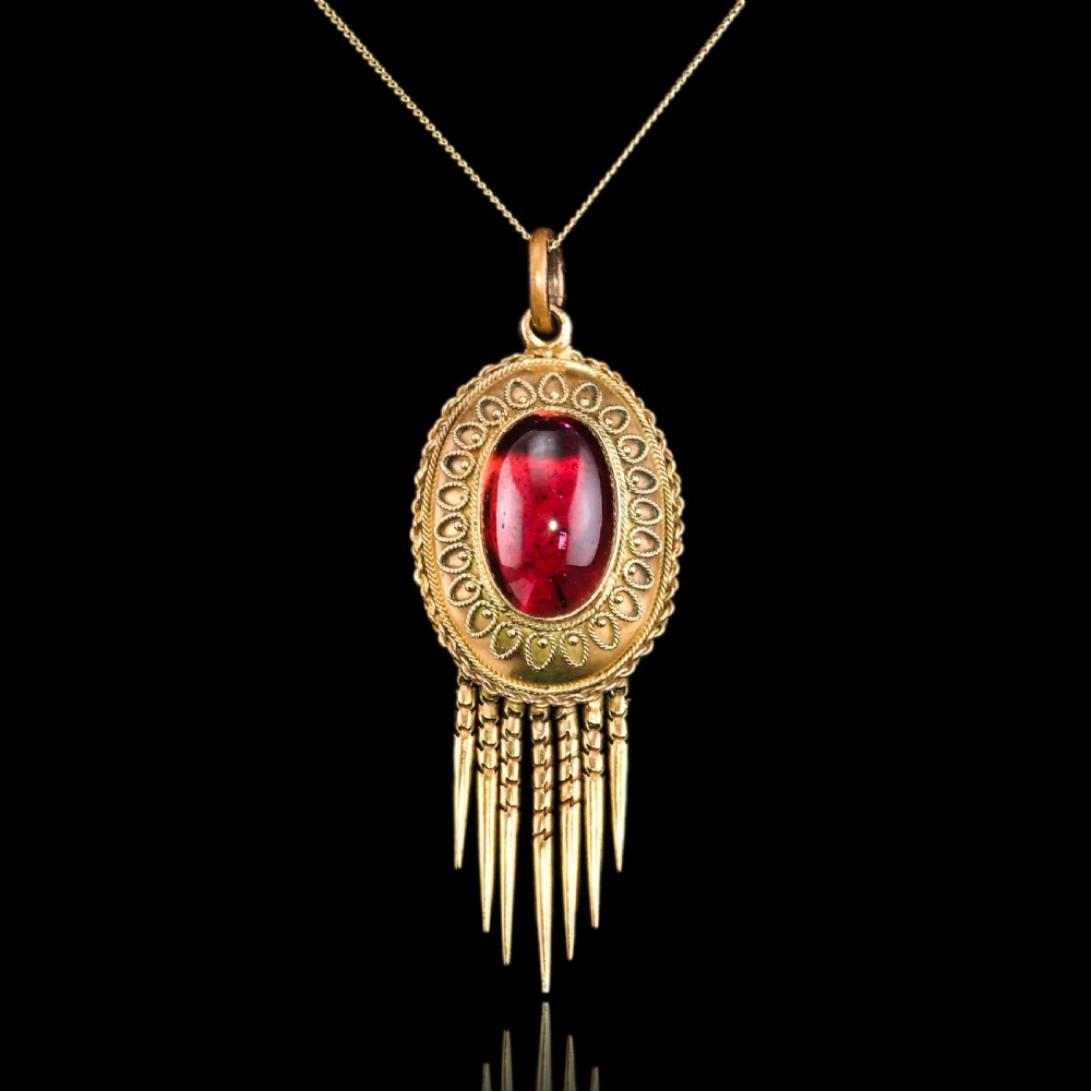 A Victorian 15ct gold oval Etruscan Revival pendant set with a central cabochon garnet and decorated with fine wirework and hanging spike tassels. View III