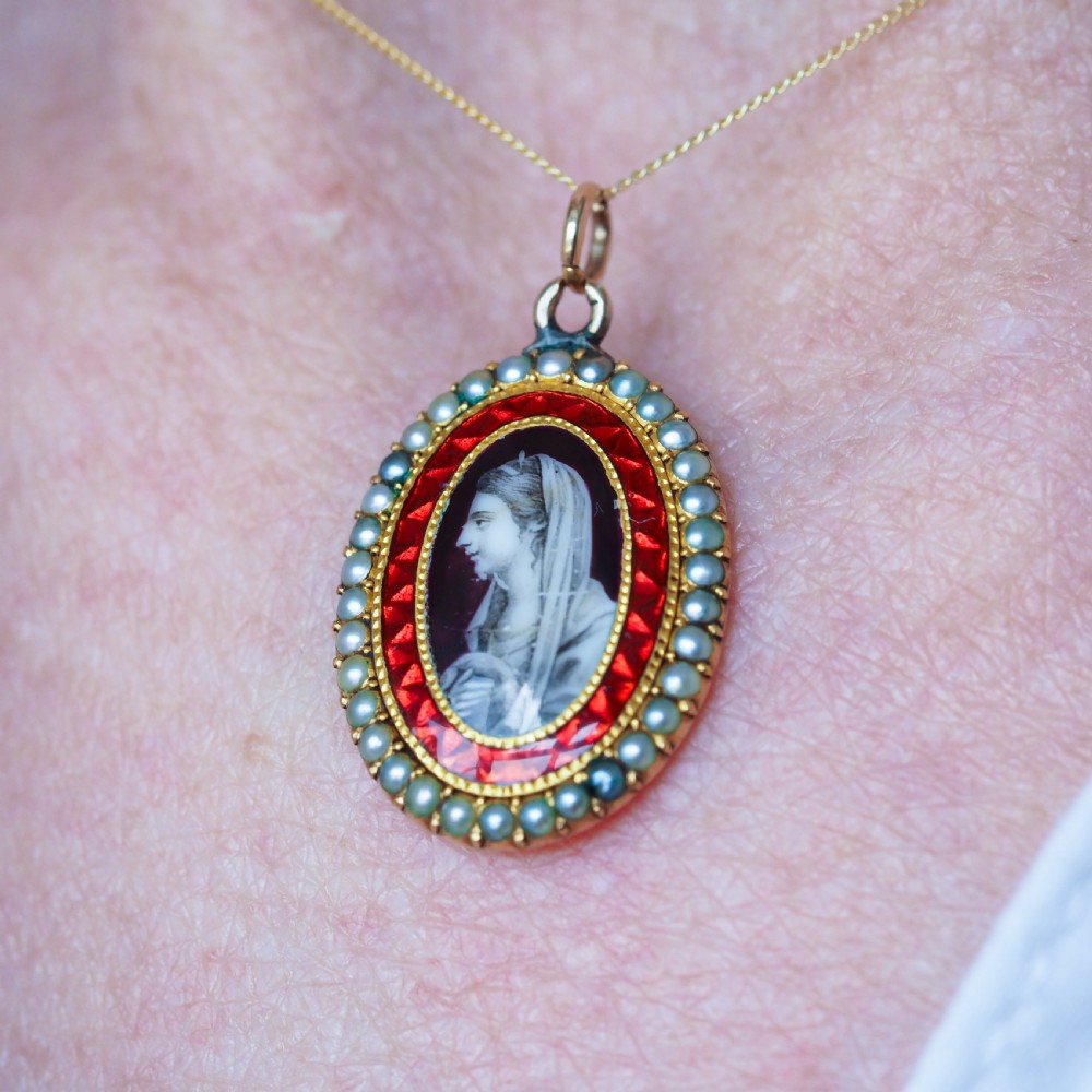 An oval Georgian gold pendant featuring a sepia miniature profile portrait surrounded by a red enamel border and a frame of seed pearls on a fine gold chain. View VI