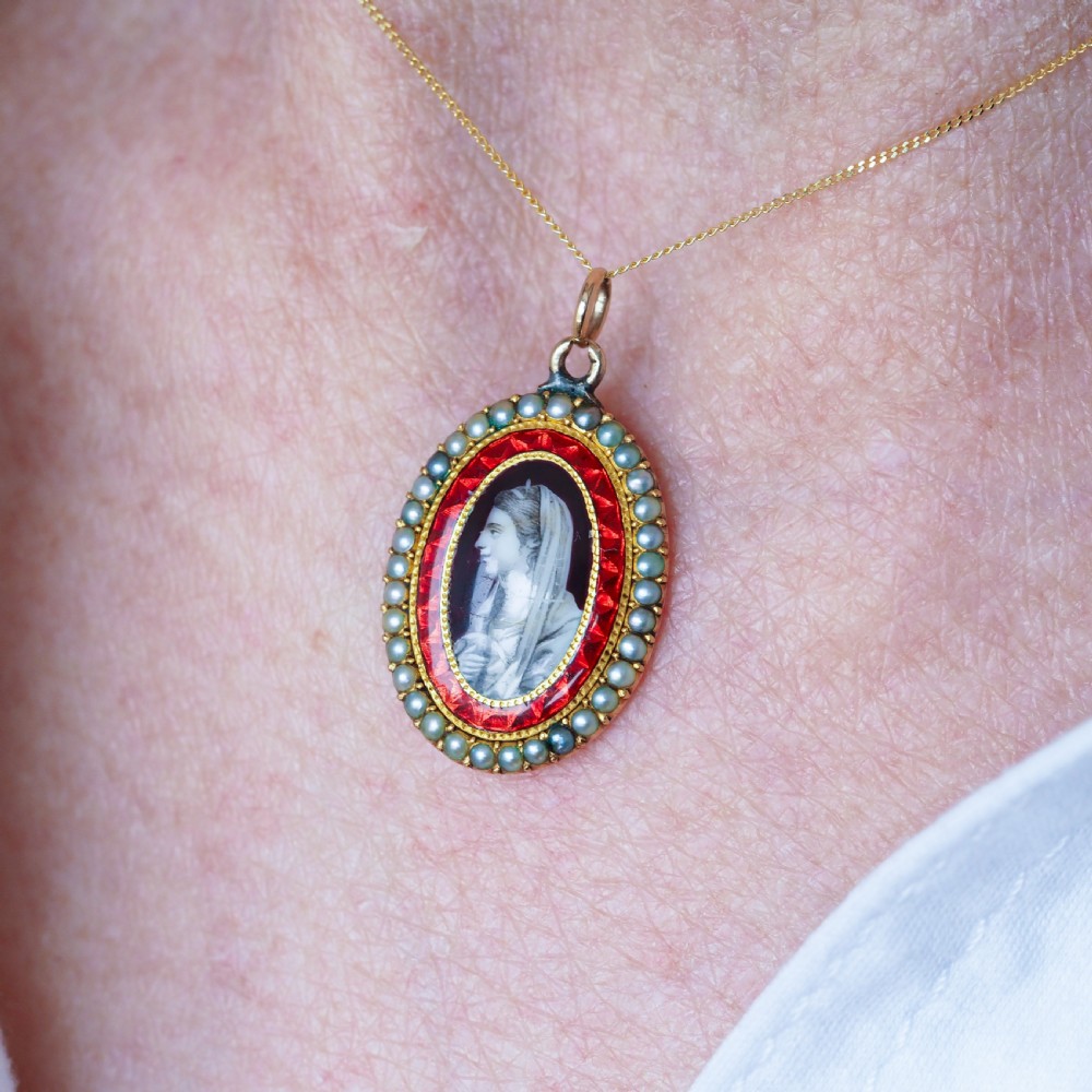 An oval Georgian gold pendant featuring a sepia miniature profile portrait surrounded by a red enamel border and a frame of seed pearls on a fine gold chain. View VII