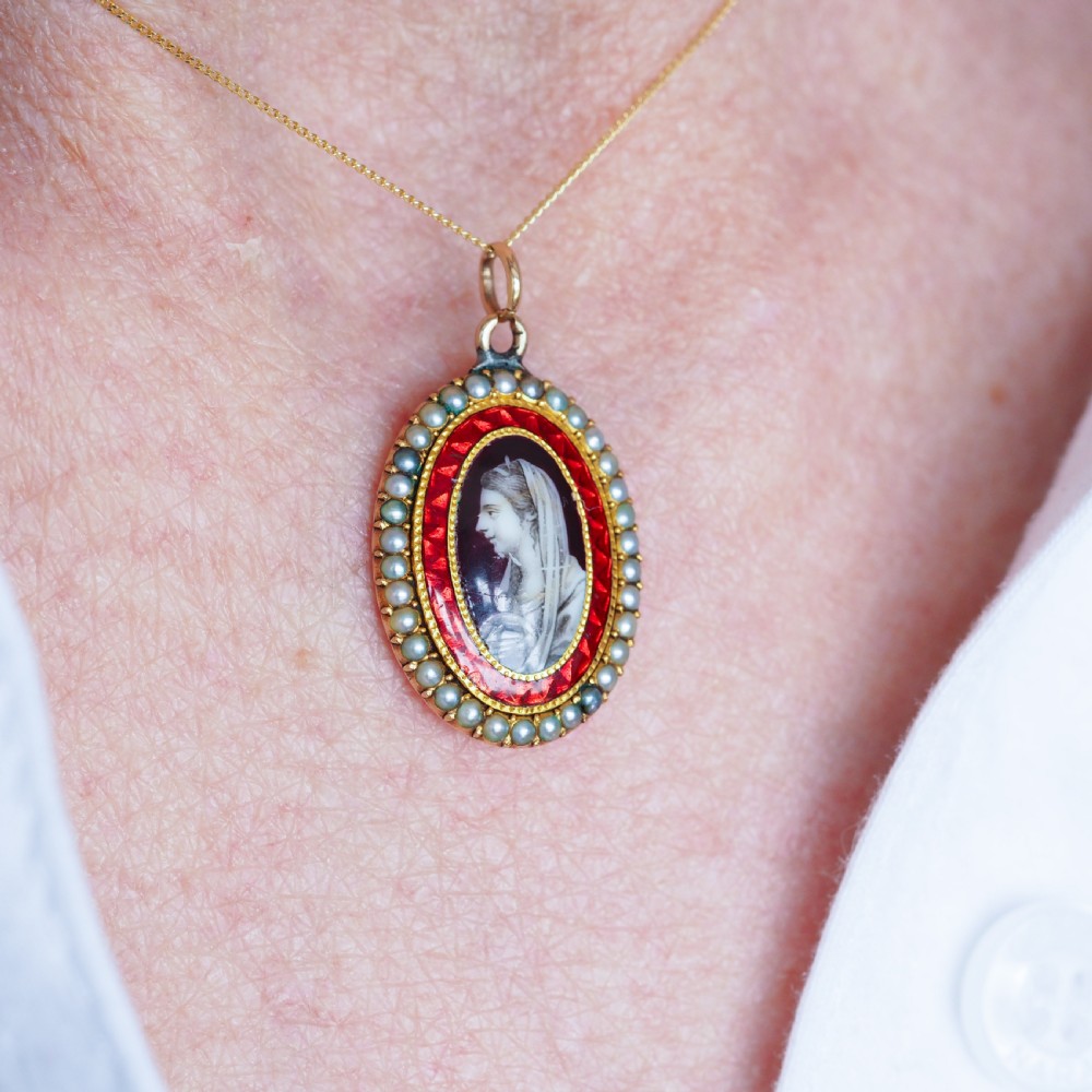 An oval Georgian gold pendant featuring a sepia miniature profile portrait surrounded by a red enamel border and a frame of seed pearls on a fine gold chain. View VIII