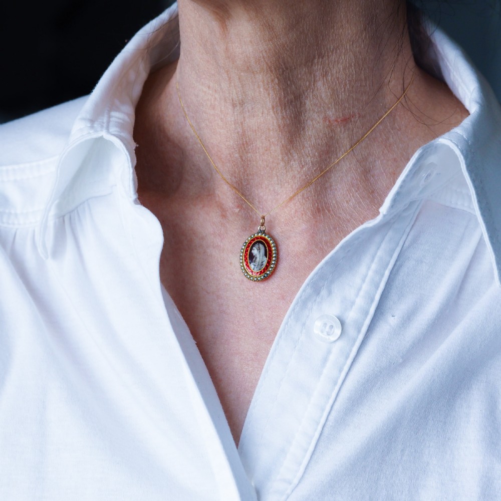 An oval Georgian gold pendant featuring a sepia miniature profile portrait surrounded by a red enamel border and a frame of seed pearls on a fine gold chain. View XI