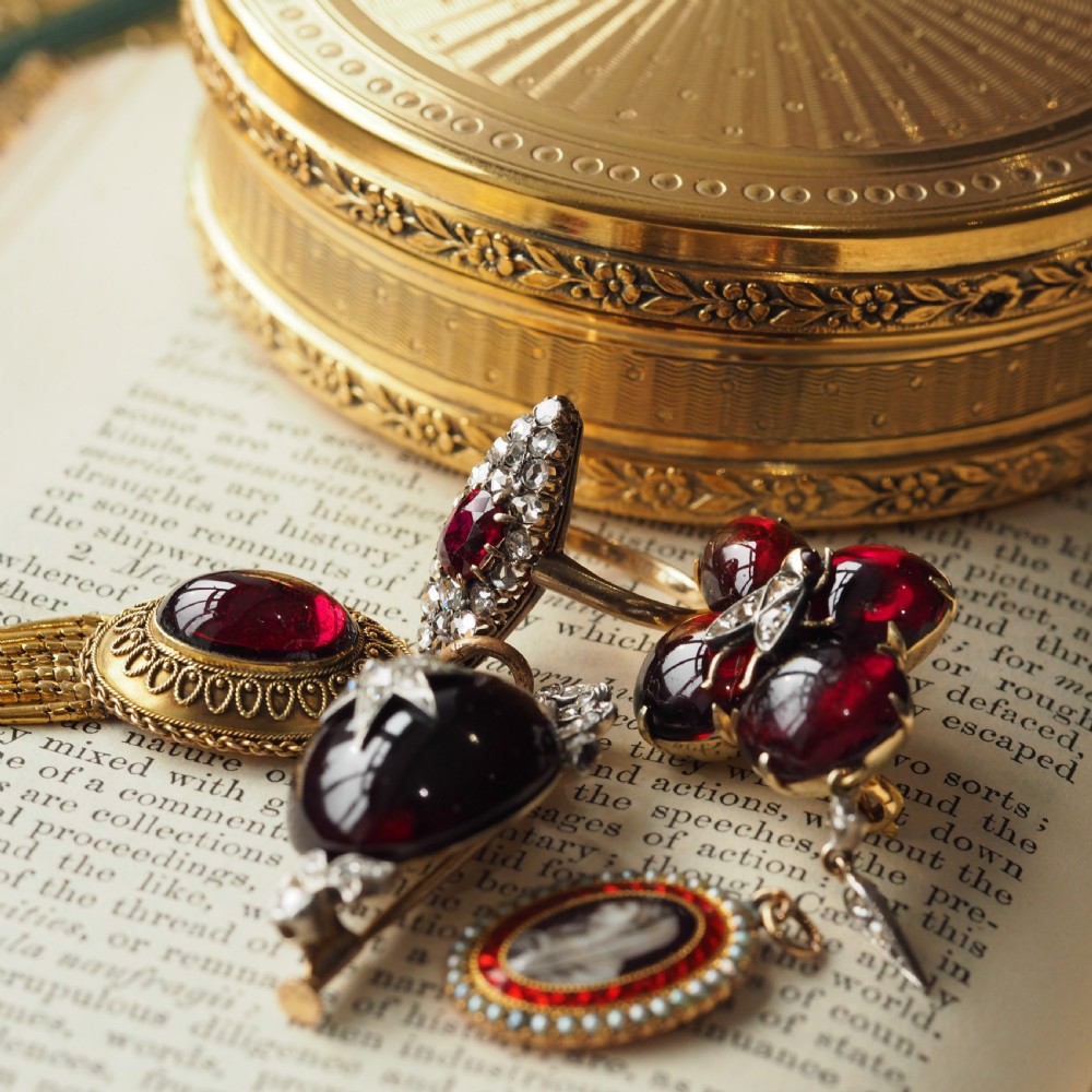 An oval Georgian gold pendant featuring a sepia miniature profile portrait surrounded by a red enamel border and a frame of seed pearls on a fine gold chain. View XVII