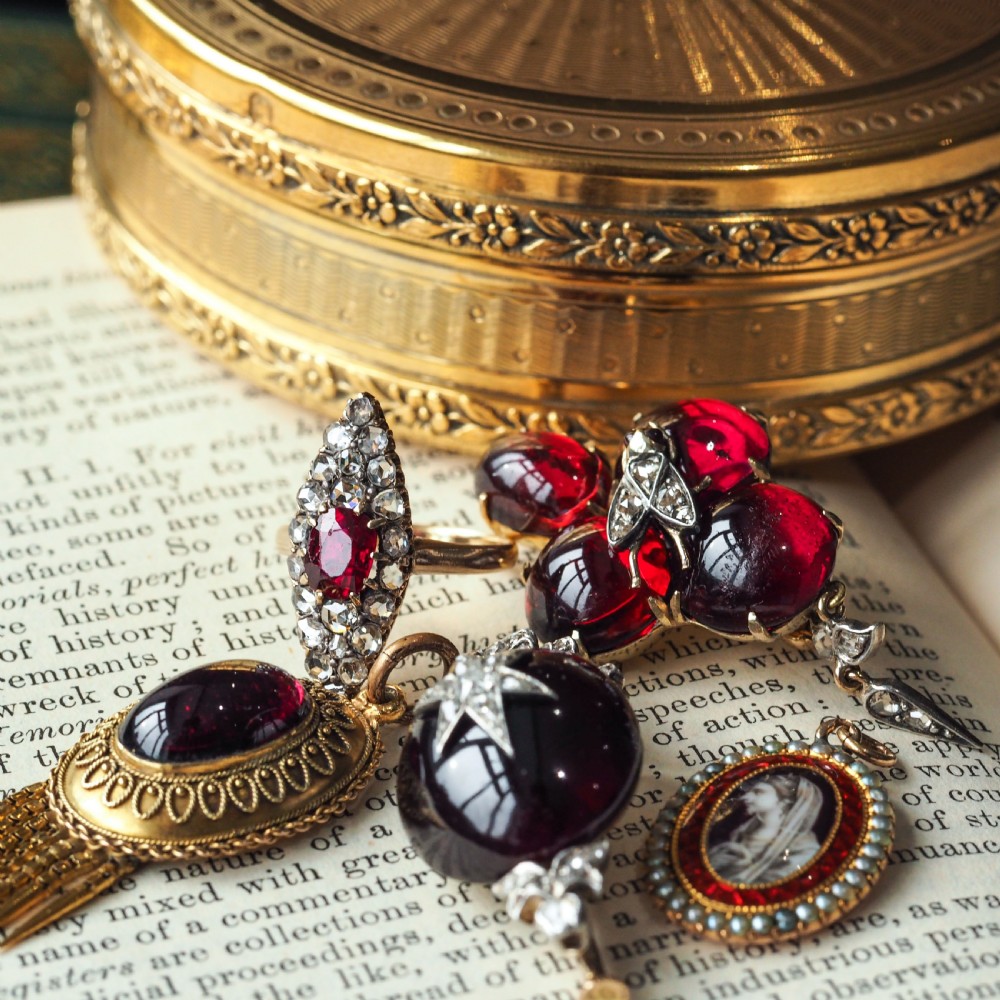 An oval Georgian gold pendant featuring a sepia miniature profile portrait surrounded by a red enamel border and a frame of seed pearls on a fine gold chain. View XVIII