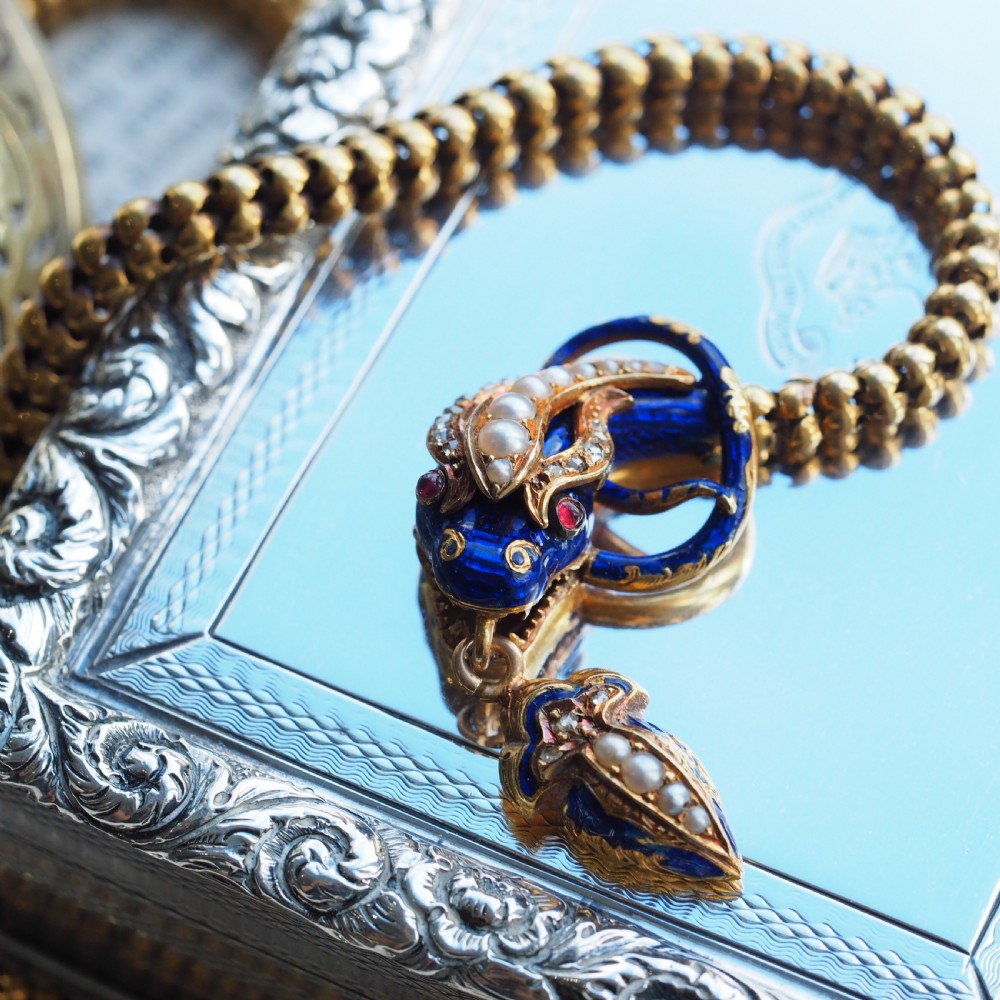 An antique Victorian 18-carat gold snake necklace featuring a flexible chain and a blue enamel serpent head decorated with seed pearls and diamonds. View II