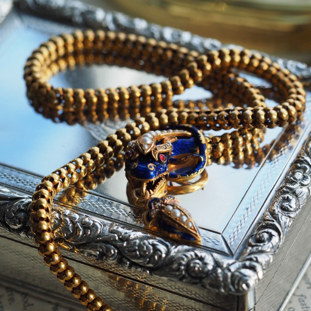 An antique Victorian 18-carat gold snake necklace featuring a flexible chain and a blue enamel serpent head decorated with seed pearls and diamonds. View III